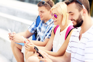 Group of friends using smartphones in the campus